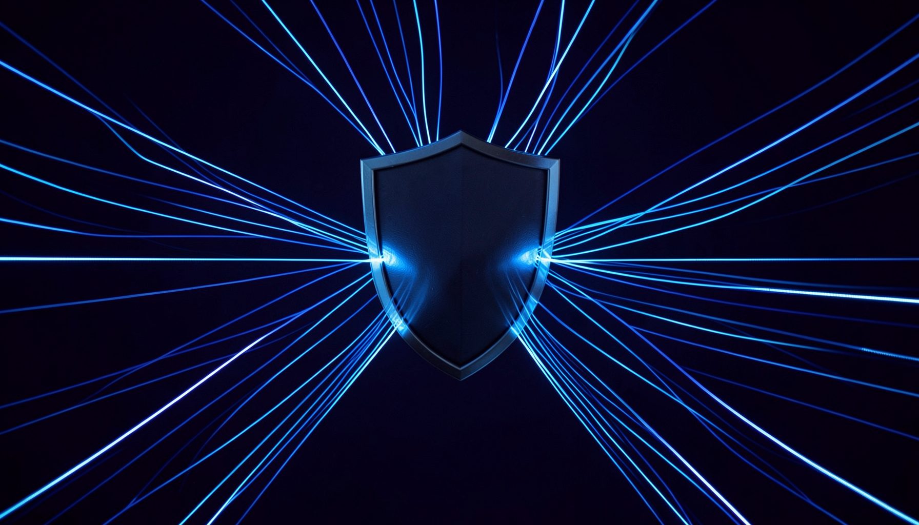 Dark indigo background with glowing fiber-optic lines converging toward a central shield